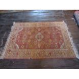 An eastern wool rug with red ground field central medallion and floral detail, within alternating