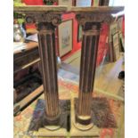 A pair of fluted columns or torcheres with ionic capitals and with antiqued finish, 110cm approx