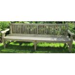 A weathered teak wood garden bench, 240cm wide