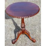 Mahogany tilt top table with carved edge on pedestal base and ball and claw feet, 20th C., 71 x 60
