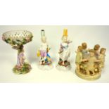 A pair of 19th Century German porcelain figural candlesticks, a Scheirholz tazza with cherub, and