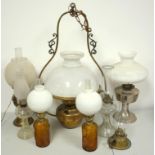 A large hanging brass oil lamp with glass shade, and seven other oil lamps (8)