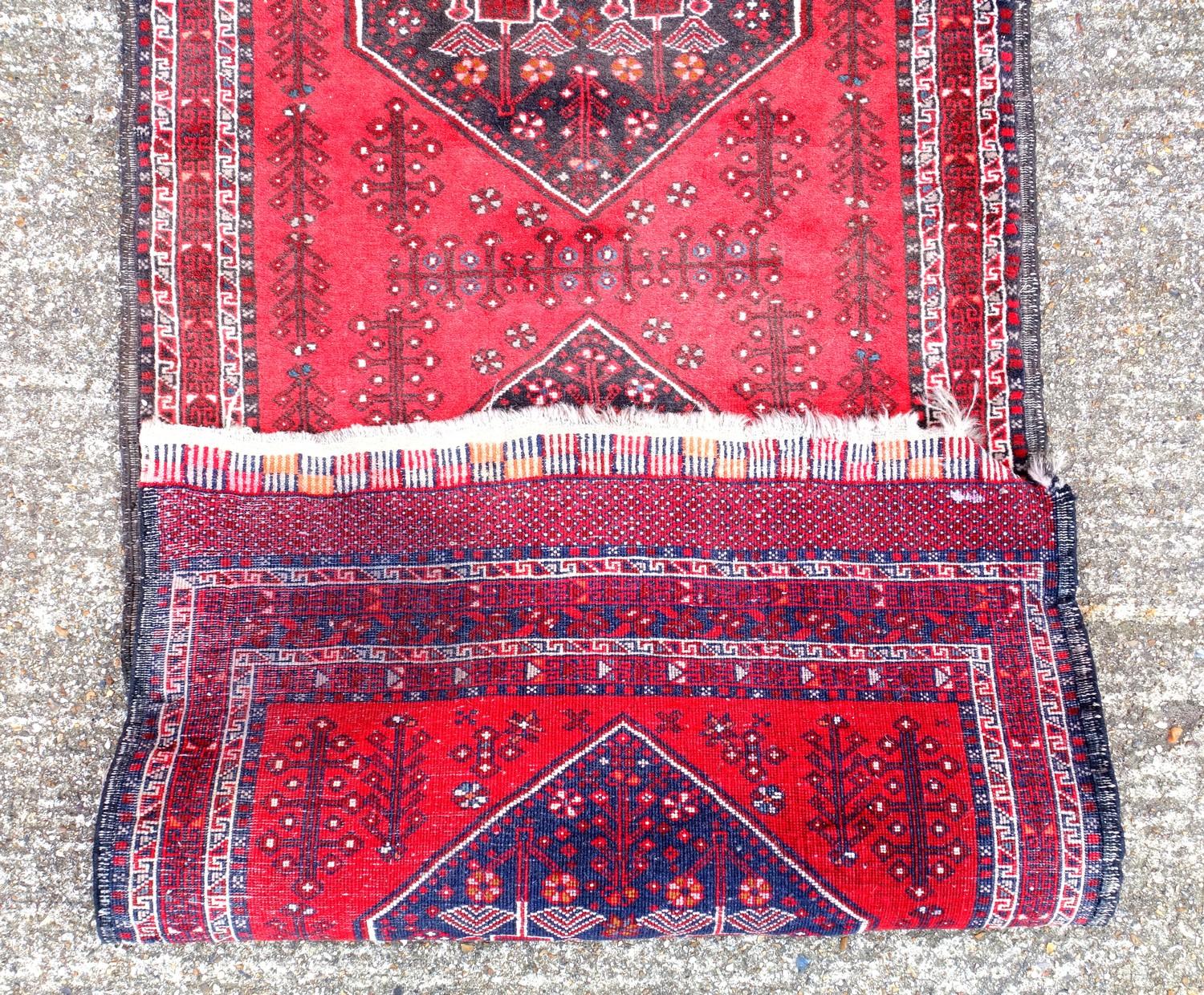 Oriental carpet runner, with three central medallions, on a deep red ground, 274 x 78 cm - Image 3 of 3