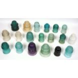 A collection of glass insulators, in aquamarine, green, purple and others, various makers,