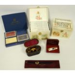 Two cased sets of Beatrix Potter books, cased opera glasses, and a BMJ lighter with enamel peacock
