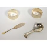 George III silver caddy spoon, hallmarked Birmingham 1817, two silver napkin rings, London 1948, a