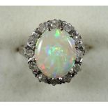 Vintage opal and diamond ring, large central oval opal within a border of diamonds, set in 18ct