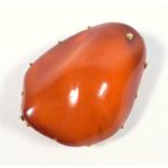 A large 1970's amber brooch mounted in unmarked gold testing as 14 ct., gross weight, 40.4 grams