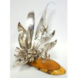 20th C. design silver floral centrepiece with five sprigs of flowers within six leaves, on a rocky