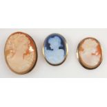 Three cameo pendant brooches in gold mounts, two shell cameos and a porcelain cameo, all with