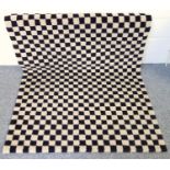 Irish wool rug of natural cream and black wool chequered design, 185 x 132 cm.