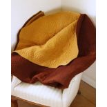 Antique woollen quilt, the ochre yellow and brown wool covers stitched with an intricate pattern