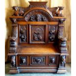 A grand 19th C oak hall bench, extensively carved in the Flemish manor, the shape pediment carved