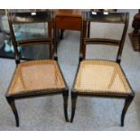 Pair of Regency style black and gilt lacquered chairs, each with a moulded rail back and cane