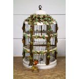 Italian ceramic cylindrical birdcage with all-over encrusted floral decoration, door a/f, with two