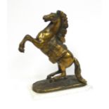 A bronzed Marly style horse figure on a white marble base, 38 cm high