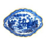 A Chinese style blue and white shaped fluted oval dish with gilded rim, the centre decorated with