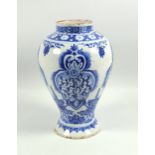 An early 19th century Continental tin glazed pottery baluster shaped vase, decorated in under