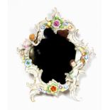 Dresden porcelain wall mirror with a shaped plate, in a putti and floral encrusted frame, 48 x 36.