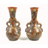 A pair of late 19th century Japanese Satsuma pottery twin handled vases decorated with figures and a