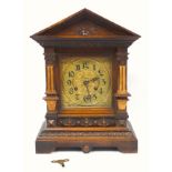 A late Victorian oak bracket clock of architectural form with pointed pediment, fluted pillars on