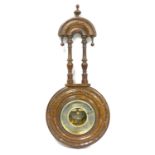 Late Victorian barometer with a circular dial enclosing an aneroid movement, in a carved walnut