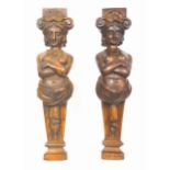 A pair of late 19th/early 20th century oak caryatids, each carved as a bare breasted female, with