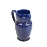 Local interest - Farnham Pottery, an owl jug ,blue glazed, with incised decoration and pronounced