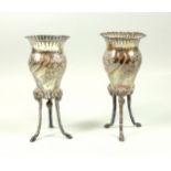 Pair of Edwardian silver baluster vases, each with embosses floral decoration and fluted rim, on 3