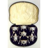 Fine Edwardian silver 12 piece cruet set of quatrefoil form, with scroll handles, on 4 open leaf and