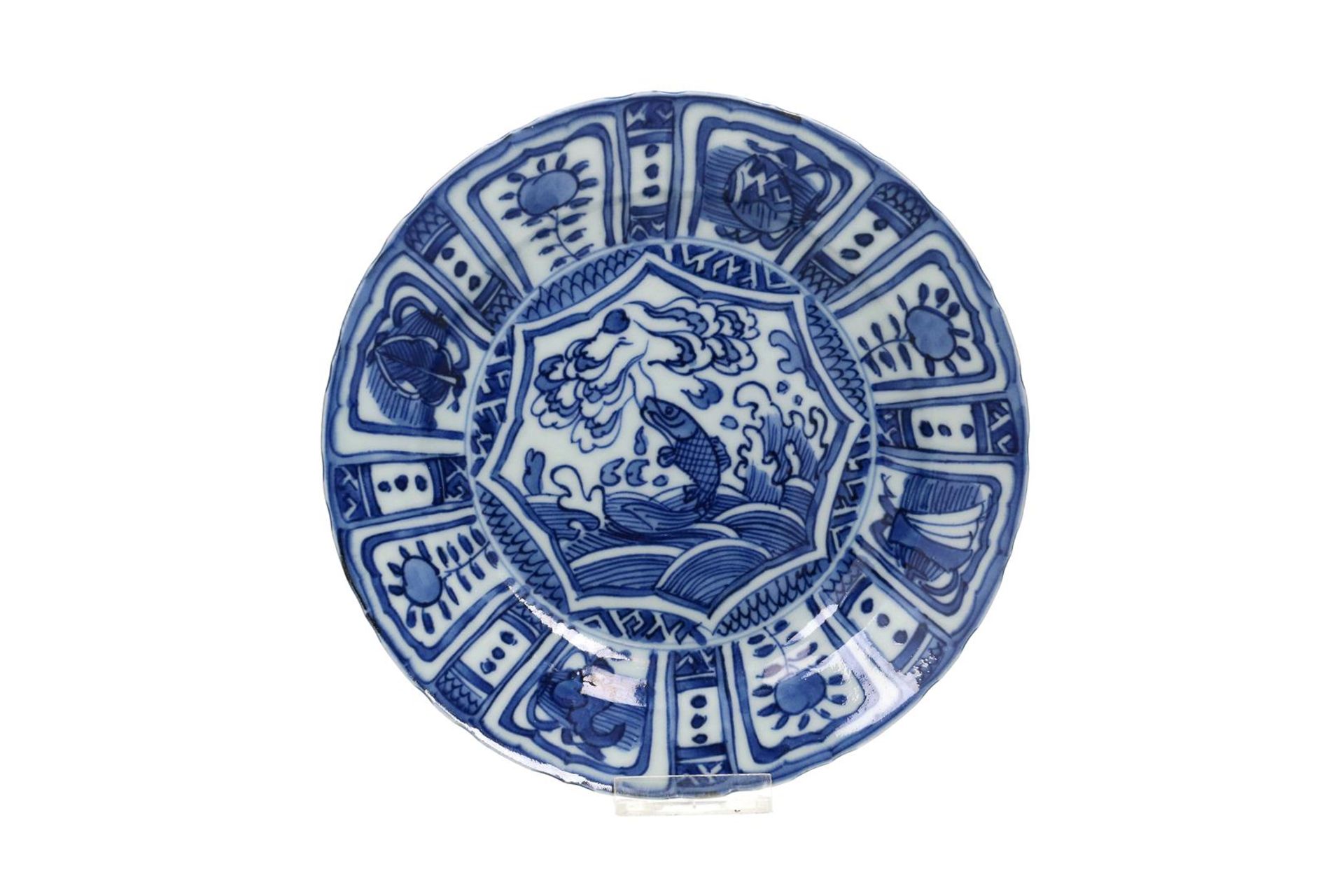 A blue and white 'kraak' porcelain dish with a scalloped rim, decorated with a carp leaping out of