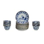 A set of nine blue and white porcelain cups and saucers decorated with a little boy with a blossom
