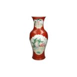 A coral red and gilded porcelain vase with polychrome decoration, depicting figures and boys in a