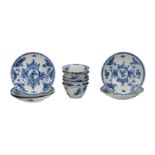 A set of six blue and white porcelain cups and saucers, decorated with a floral decor and a fence in