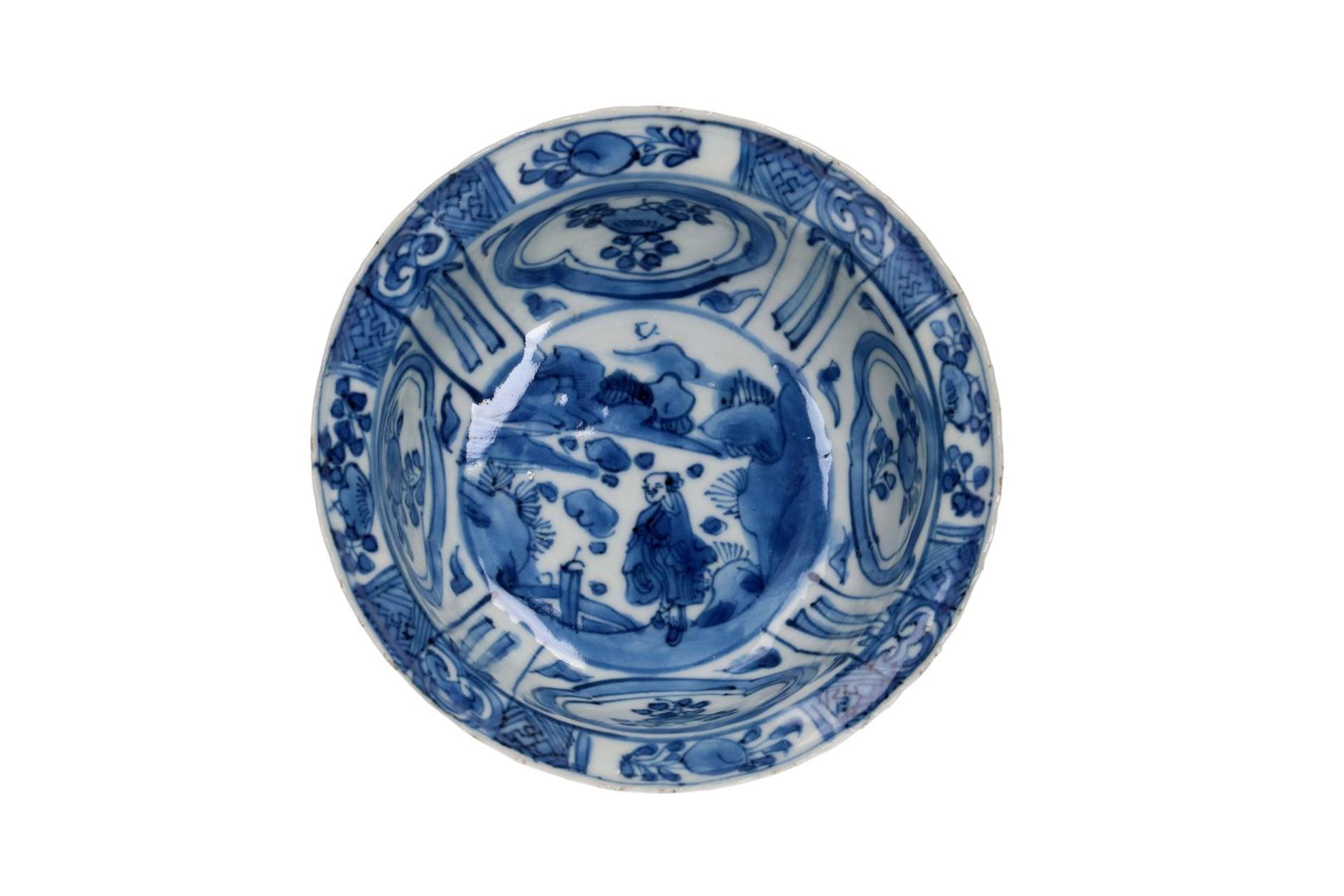A blue and white 'kraak' porcelain 'klapmuts' bowl with a scalloped rim, decorated with a figure