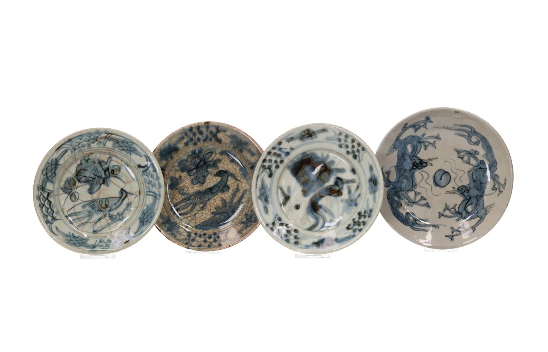 A set of four blue and white Swatow dishes, one decorated with two dragons chasing a flaming pearl