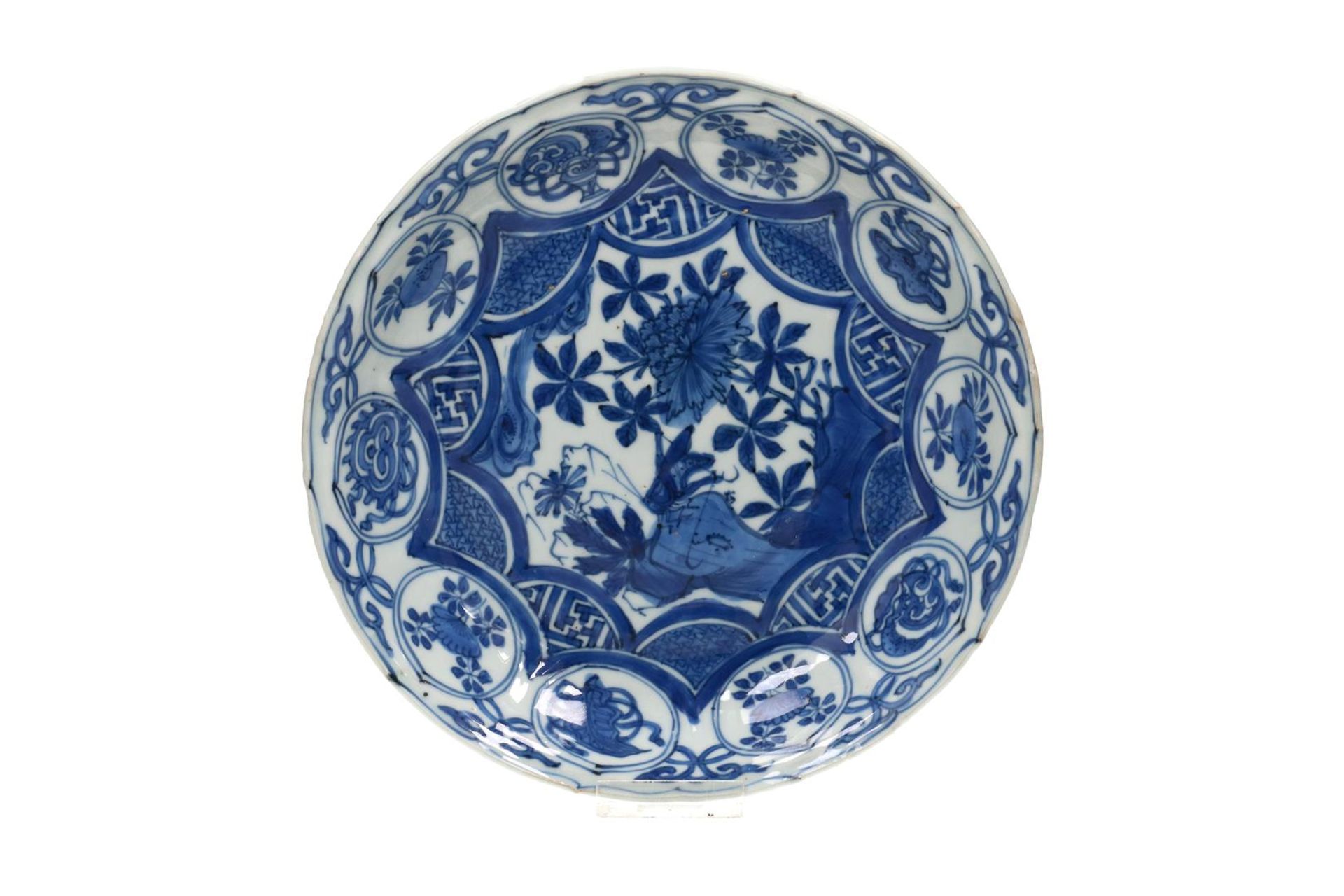 A blue and white 'kraak' porcelain dish with a scalloped rim, decorated with a cricket on a rock and