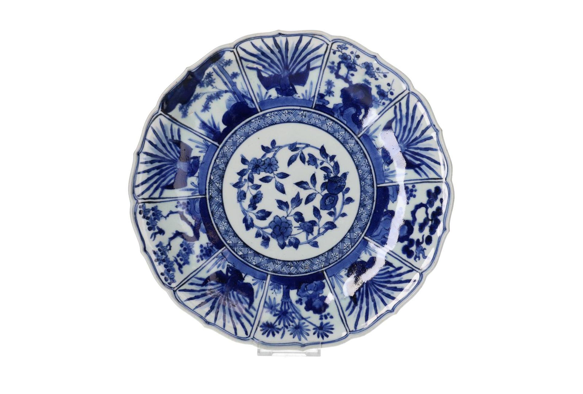 A blue and white Arita porcelain deep charger with scalloped rim, decorated with peacocks, plants