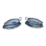 A pair of blue and white porcelain sauce boats with dish and scalloped rim, decorated with pagodas