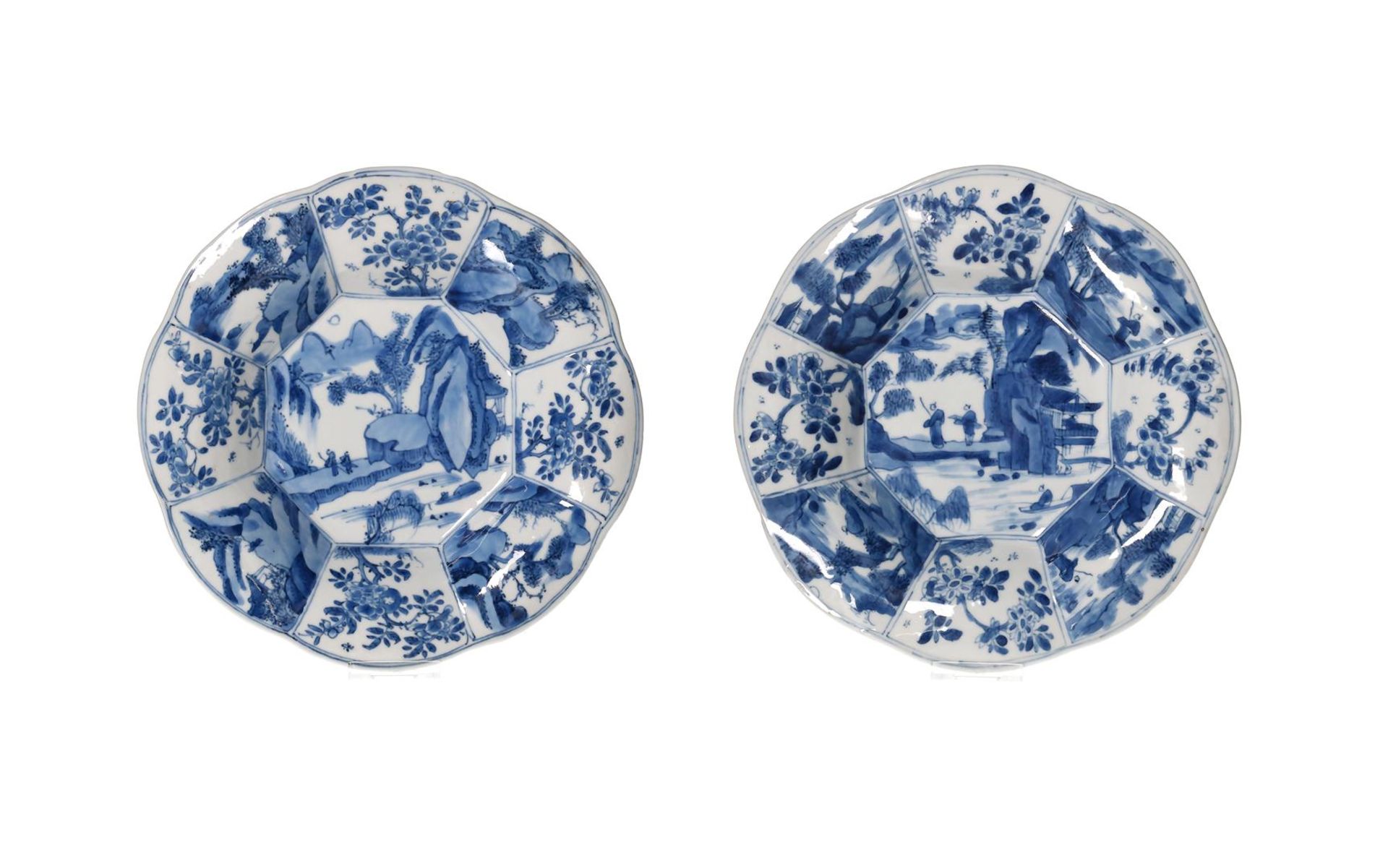 A pair of blue and white porcelain dishes, with a decor of travelers in a landscape and the lobed