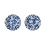 A pair of blue and white porcelain dishes, with a decor of travelers in a landscape and the lobed