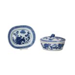 An oval blue and white porcelain lidded box and saucer, decorated with flowers and a meander.