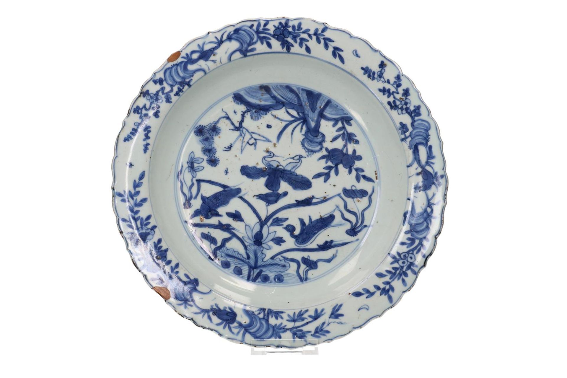 A blue and white porcelain deep charger with a scalloped rim, decorated with two ducks in a lotus