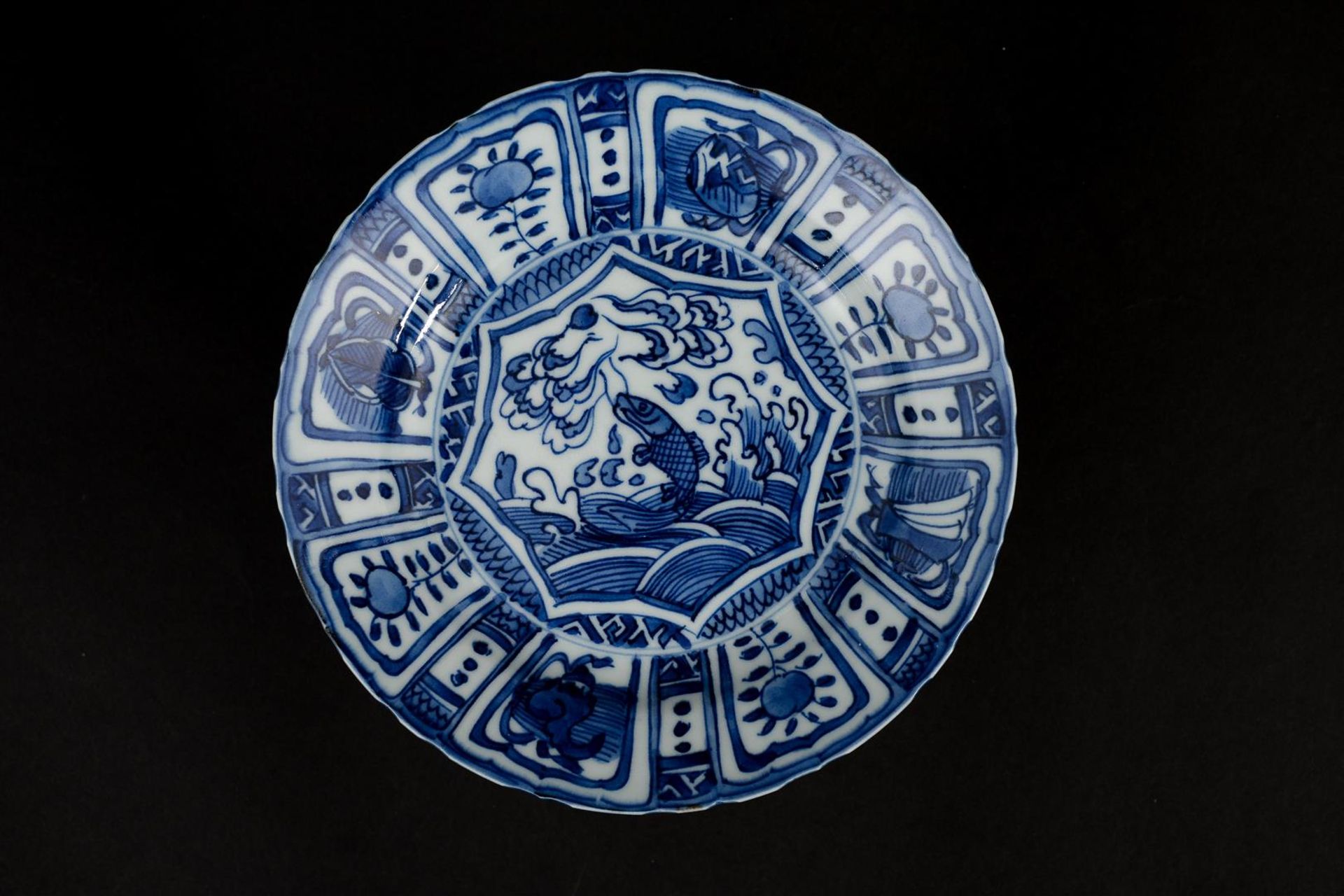 A blue and white 'kraak' porcelain dish with a scalloped rim, decorated with a carp leaping out of - Bild 2 aus 4