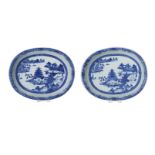 A pair of blue and white porcelain salad bowls, decorated with pagodas in a river landscape.