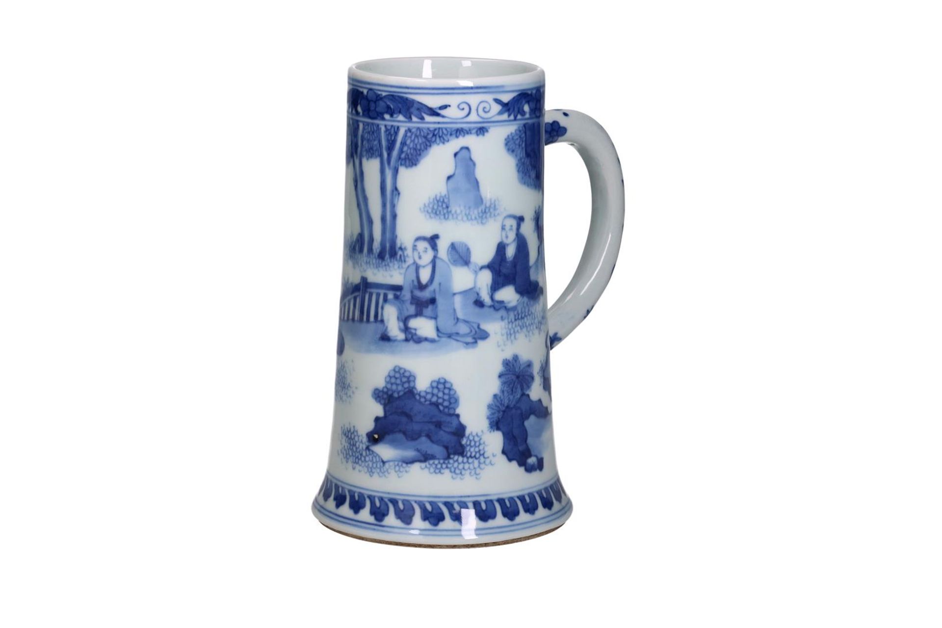 A blue and white porcelain beer mug decorated with an outdoor scene with seated figures. Unmarked.