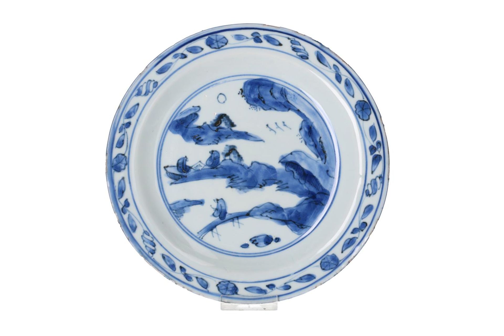 A blue and white porcelain dish, decorated with two reading monks in a mountainous landscape.