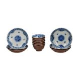 A set of six blue and white porcelain cups and saucers, the reverse covered in capuchin glaze,
