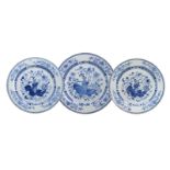 A set of three blue and white porcelain chargers, decorated with a vase with flowers on a big