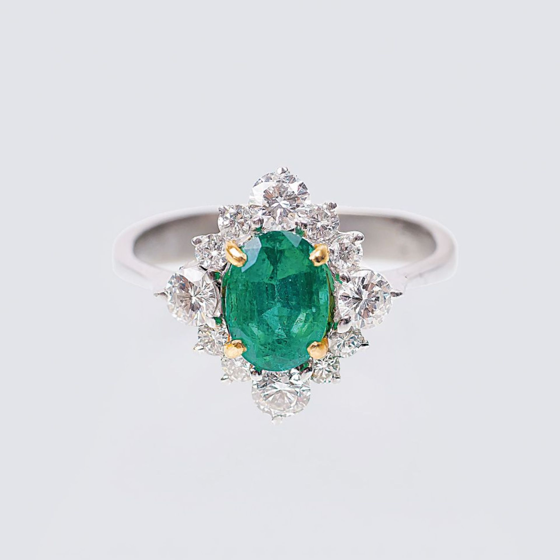 Smaragd-Brillant-Ring. 14 kt. WG, gest. In GG-Krappen der Smaragd im Ovalschliff ca. 0,95 ct. (ca.